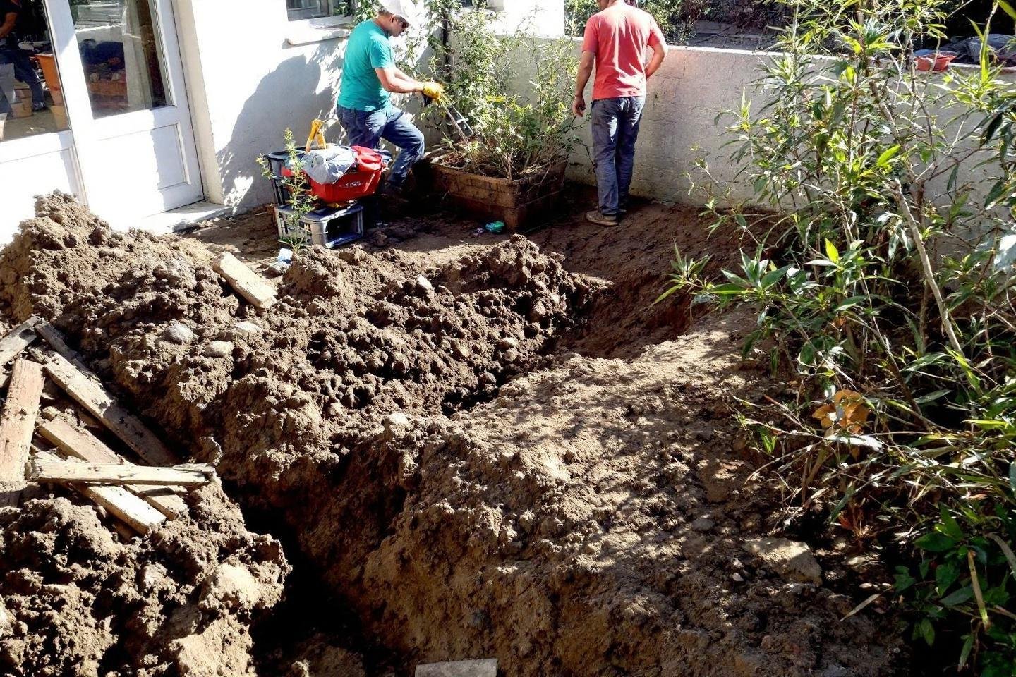 Deux personnes creusant des tranchées profondes avec une mini-pelle